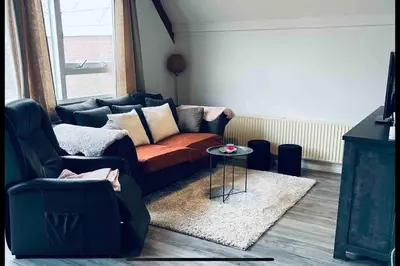 a living room with a couch and a table at Leuke bungalow in Noord-Holland in Opmeer