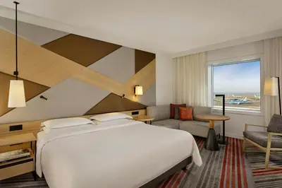 a hotel room with a bed and a desk and chair at Sheraton Amsterdam Airport Hotel and Conference Center in Schiphol