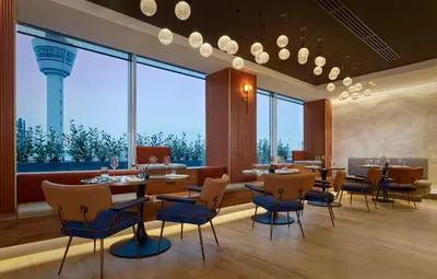 a restaurant with tables and chairs and a large window at Sheraton Amsterdam Airport Hotel and Conference Center in Schiphol