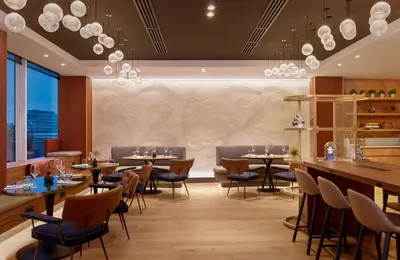 a restaurant with tables and chairs and a large window at Sheraton Amsterdam Airport Hotel and Conference Center in Schiphol