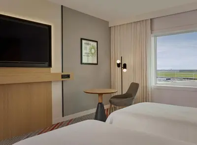 a hotel room with a bed and a tv and a table at Sheraton Amsterdam Airport Hotel and Conference Center in Schiphol