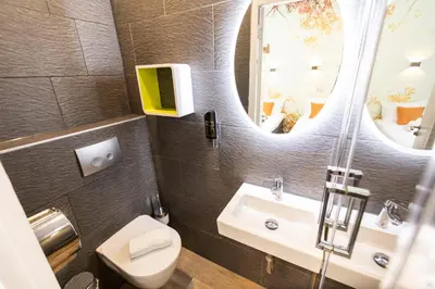 a bathroom with a toilet and a sink and a mirror at Hotel Pagi in Amsterdam