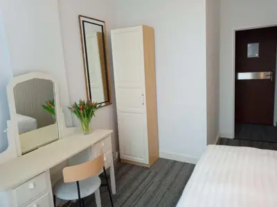 a bedroom with a desk and a bed and a mirror at Hotel Verdi in Amsterdam