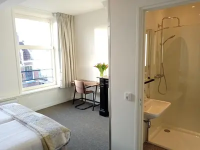 a hotel room with a bed and a sink and a bathroom at Hotel Verdi in Amsterdam