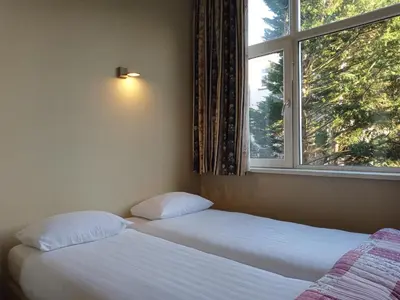 two beds in a room with a window at Hotel Verdi in Amsterdam