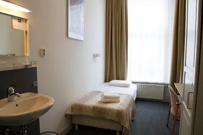 a hotel room with a bed and a sink at Hotel Verdi in Amsterdam