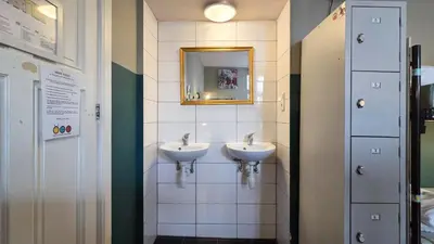 a bathroom with two sinks and a mirror on the wall at Hostel Cosmos Amsterdam in Amsterdam