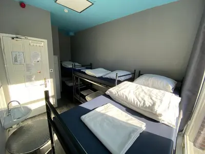 a hospital room with two beds and a table at Hostel Cosmos Amsterdam in Amsterdam
