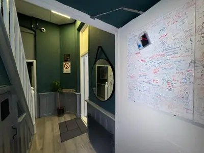 a hallway with a mirror and writing on the wall at Hostel Cosmos Amsterdam in Amsterdam