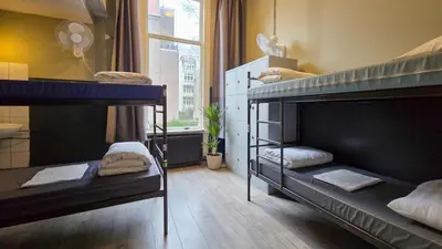 two bunk beds in a room with a window at Hostel Cosmos Amsterdam in Amsterdam