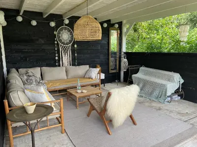 a living room with a couch and a table at Huisje op de dijk in Kortenhoef