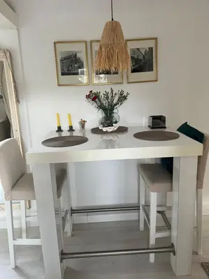 a white dining table with two chairs and a table at Huisje op de dijk in Kortenhoef