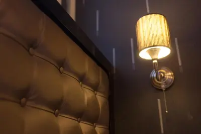 a lamp on a wall next to a couch at Hotel Hermitage Amsterdam in Amsterdam