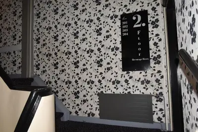 a clock on a wall with black flowers on it at Hotel Hermitage Amsterdam in Amsterdam
