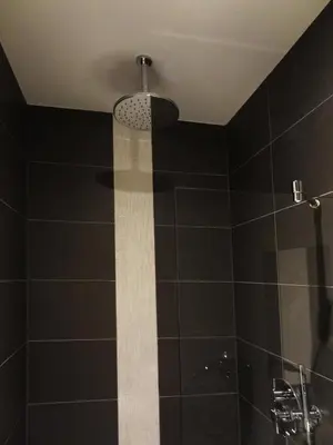 a bathroom with a black tiled shower with a ceiling at Sara's Boutique Hotel in Amsterdam