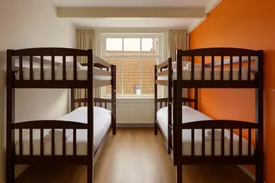 two bunk beds in a room with an orange wall at Hotel Prinsenhof Amsterdam in Amsterdam