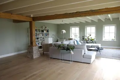 a living room with a couch and a table at Farmvilla with hottub and outdoor kitchen in Beets