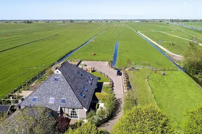 an aerial view of a house in a field at Farmvilla with hottub and outdoor kitchen in Beets