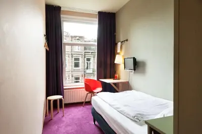 a hotel room with a bed and a window at Hotel The Neighbour's Magnolia in Amsterdam