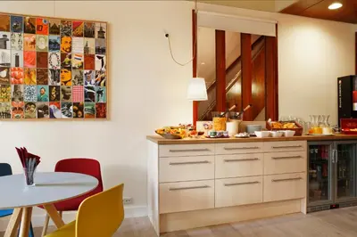 a kitchen with a counter and a table with chairs at Hotel The Neighbour's Magnolia in Amsterdam