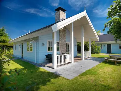 a white house with a chimney on top at Holiday Home near Dutch Coast & Forest in Noordwijk
