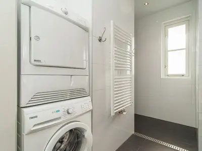 a white laundry room with a washer and dryer at Holiday Home near Dutch Coast & Forest in Noordwijk