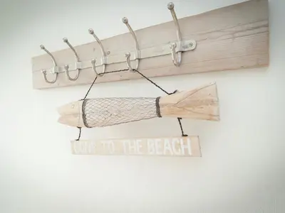 a piece of driftwood and a sign that says gone to the beach at Holiday Home near Dutch Coast & Forest in Noordwijk
