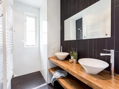 a bathroom with two sinks on a wooden counter at Holiday Home near Dutch Coast & Forest in Noordwijk