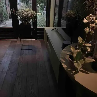 a room with a table with a vase of flowers on it at Bijzonder stadshuis met diepe moderne tuin. in Alphen aan den Rijn