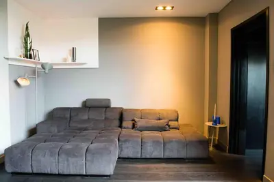 a large couch sitting in a living room at Bijzonder stadshuis met diepe moderne tuin. in Alphen aan den Rijn