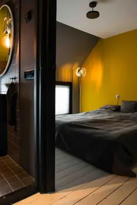 a bedroom with a bed and a bathroom with a mirror at Bijzonder stadshuis met diepe moderne tuin. in Alphen aan den Rijn
