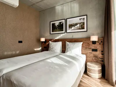 a large white bed in a room with two pictures on the wall at Hajé Nieuwegein in Nieuwegein