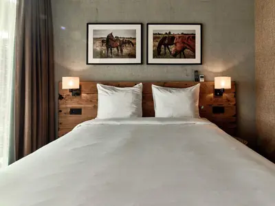 a bedroom with a large white bed with two pictures on the wall at Hajé Nieuwegein in Nieuwegein