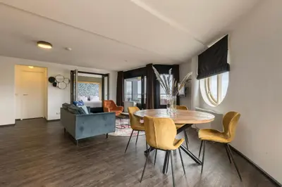 a living room with a dining room table and chairs at Leonardo Hotel IJmuiden Seaport Beach in IJmuiden