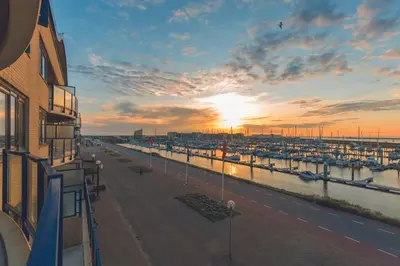 a view of a marina at sunset from a building at Leonardo Hotel IJmuiden Seaport Beach in IJmuiden