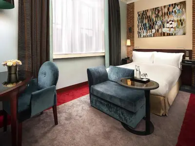 a hotel room with a bed and a chair at Sofitel Legend The Grand Amsterdam in Amsterdam