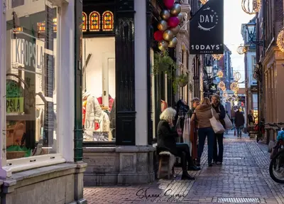 a group of people walking down a street in front of shops at ApartHotel Trendy by Urban Home Stay in Alkmaar