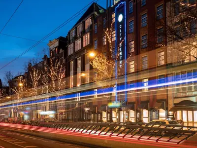a city street with a train passing by a building at WestCord City Centre Hotel in Amsterdam