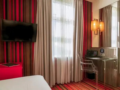 a hotel room with a bed and a television at WestCord City Centre Hotel in Amsterdam