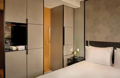a bedroom with a large bed and a cabinet at Park Plaza Vondelpark Amsterdam in Amsterdam