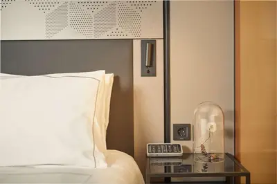 a bedroom with a bed and a table with a clock at Park Plaza Vondelpark Amsterdam in Amsterdam