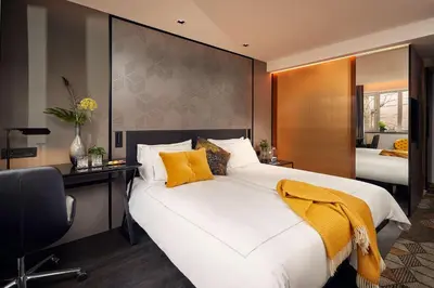 a bedroom with a large white bed and a desk at Park Plaza Vondelpark Amsterdam in Amsterdam