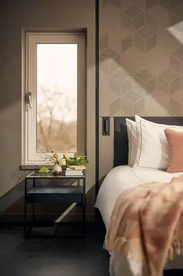 a bedroom with a bed and a table with a window at Park Plaza Vondelpark Amsterdam in Amsterdam