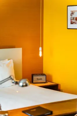 a bedroom with a bed and a clock on a table at Vesper Hotel in Noordwijk aan Zee