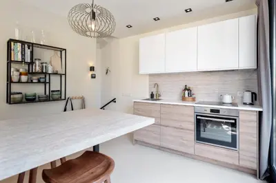 a kitchen with white cabinets and a counter top at The Modern Burrow in Zandvoort