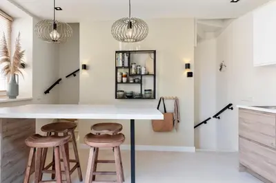 a kitchen with a counter and two stools at The Modern Burrow in Zandvoort