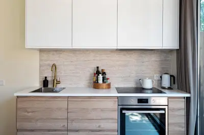 a kitchen with white cabinets and a stove top oven at The Modern Burrow in Zandvoort