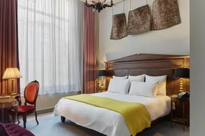 a hotel room with a bed and a chair at Pulitzer Amsterdam in Amsterdam