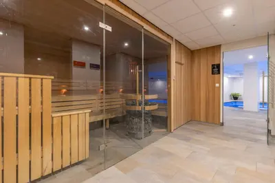 a lobby with glass walls in a building at Fletcher Hotel Jan van Scorel in Schoorl