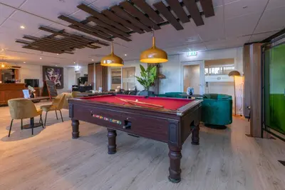 a pool table in the middle of a room at Fletcher Hotel Jan van Scorel in Schoorl